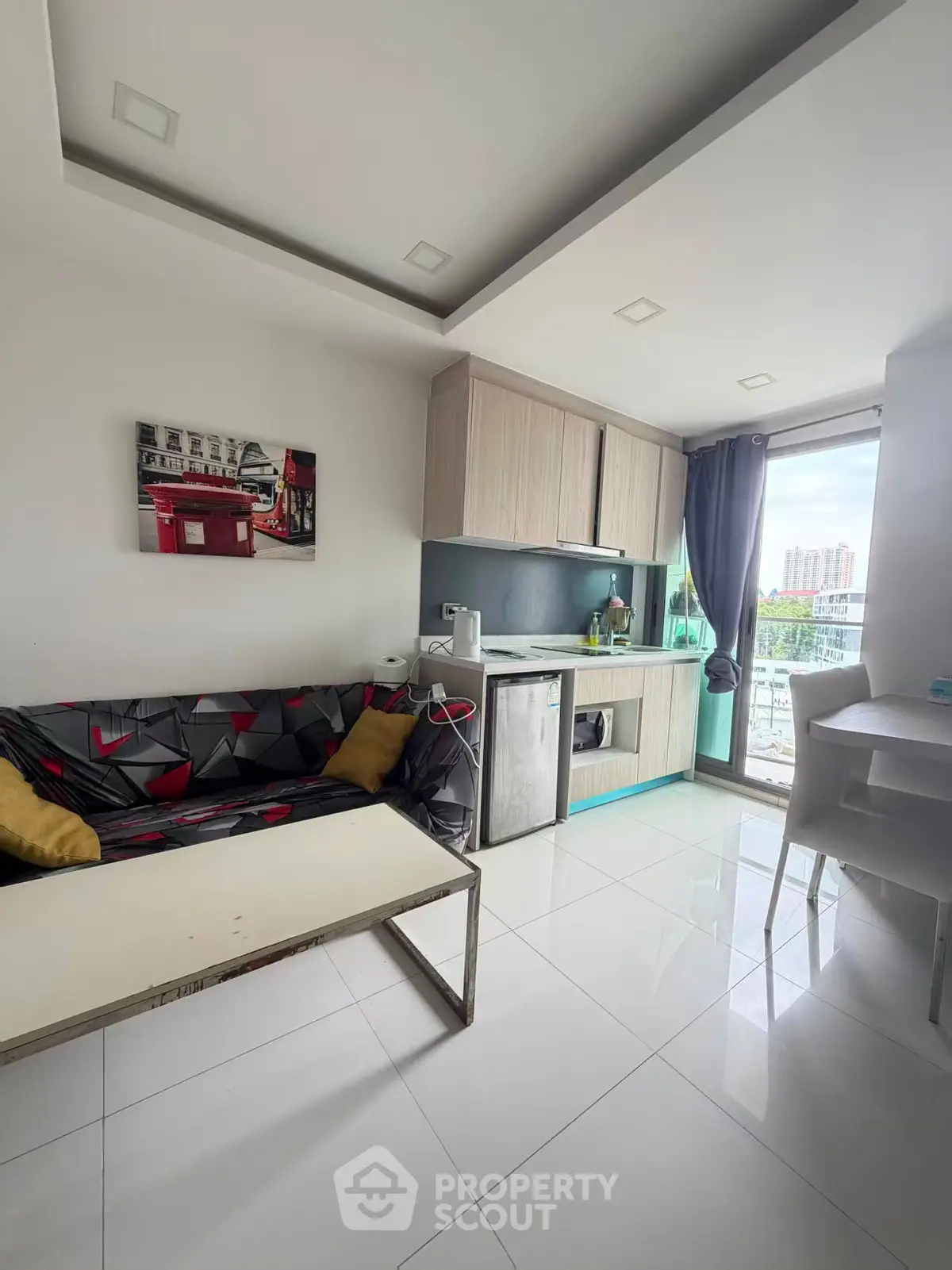 Modern open-layout living room with compact kitchen and city view balcony.