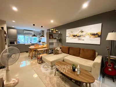 Modern living room with cozy sofa and open kitchen layout, perfect for family gatherings.
