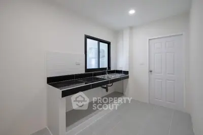 Modern minimalist kitchen with sleek black countertops and white cabinetry