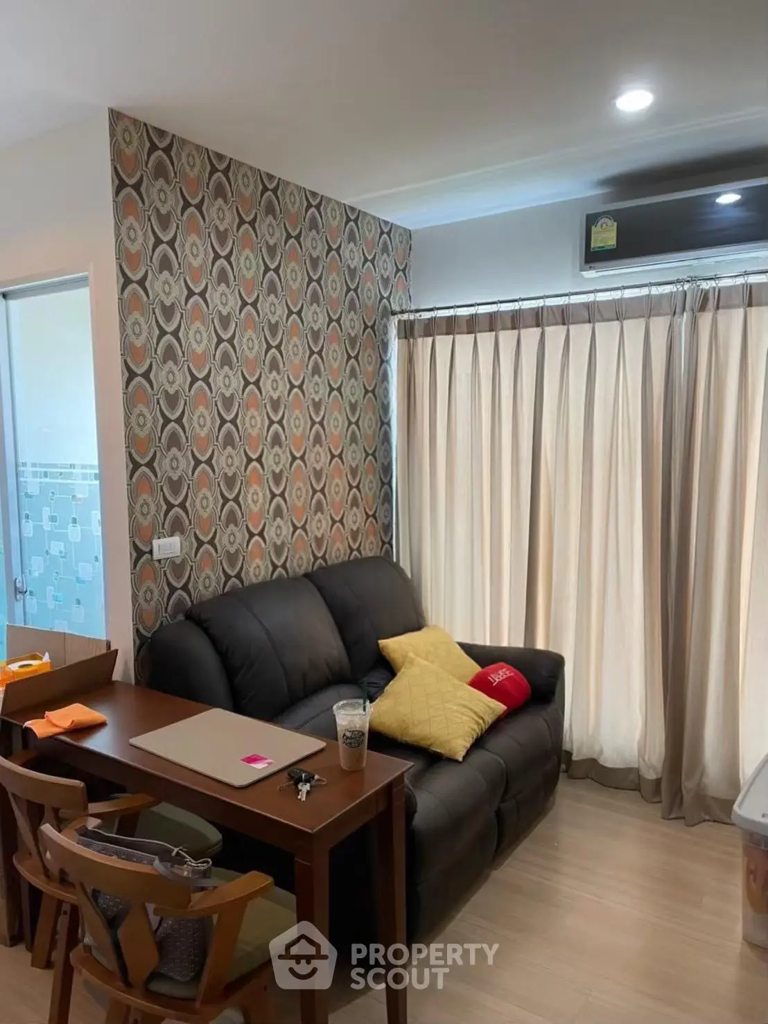 Cozy living room with stylish wallpaper and comfortable seating in modern apartment.