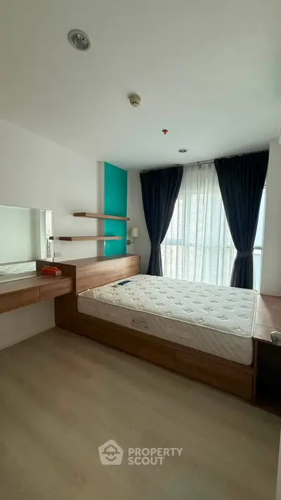 Modern bedroom with natural light, wooden furniture, and stylish decor in a contemporary apartment.