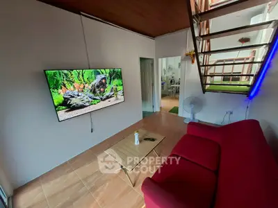 Modern living room with wall-mounted TV and stylish red sofa