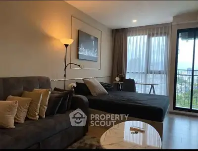 Modern living room with city view, featuring cozy sofa and stylish decor in a high-rise apartment.