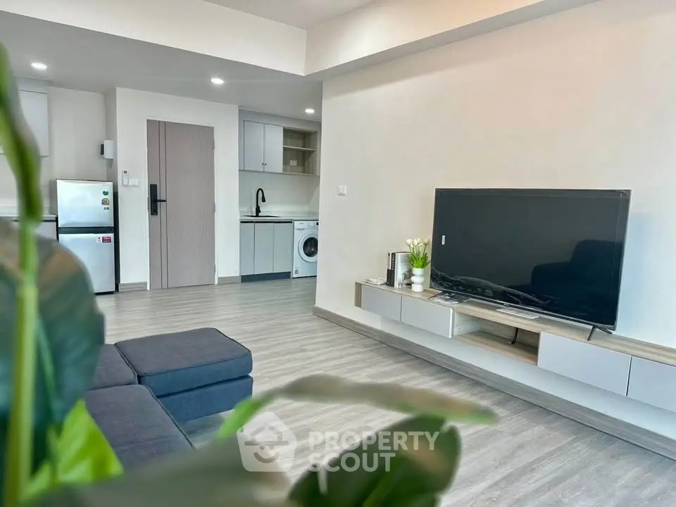 Modern living room with sleek design and integrated kitchen appliances