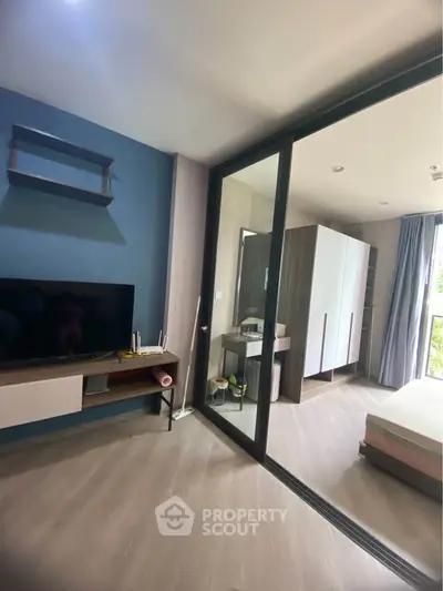 Modern bedroom with glass partition and stylish decor in a contemporary apartment.