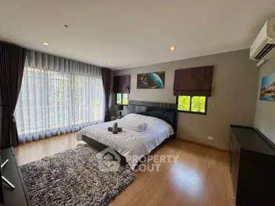 Spacious modern bedroom with large windows and elegant decor