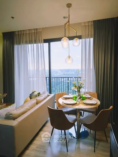 Stylish living room with dining area and stunning city view from balcony.
