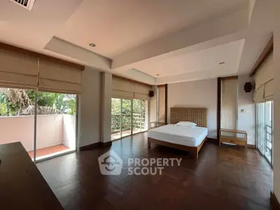 Spacious bedroom with large windows and balcony access in modern home