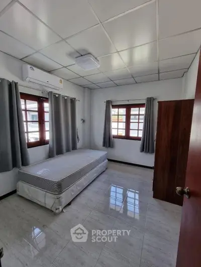 Spacious bedroom with natural light and air conditioning