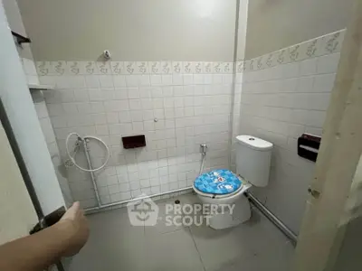 Compact bathroom with tiled walls and basic fixtures