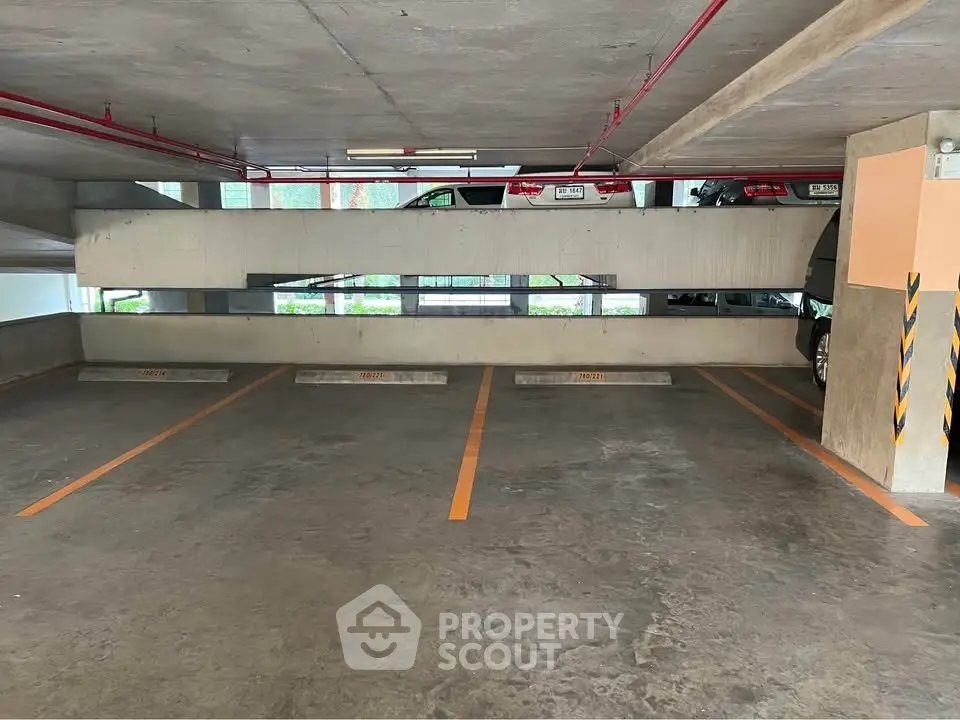 Spacious indoor parking area with multiple parking slots in a modern building.