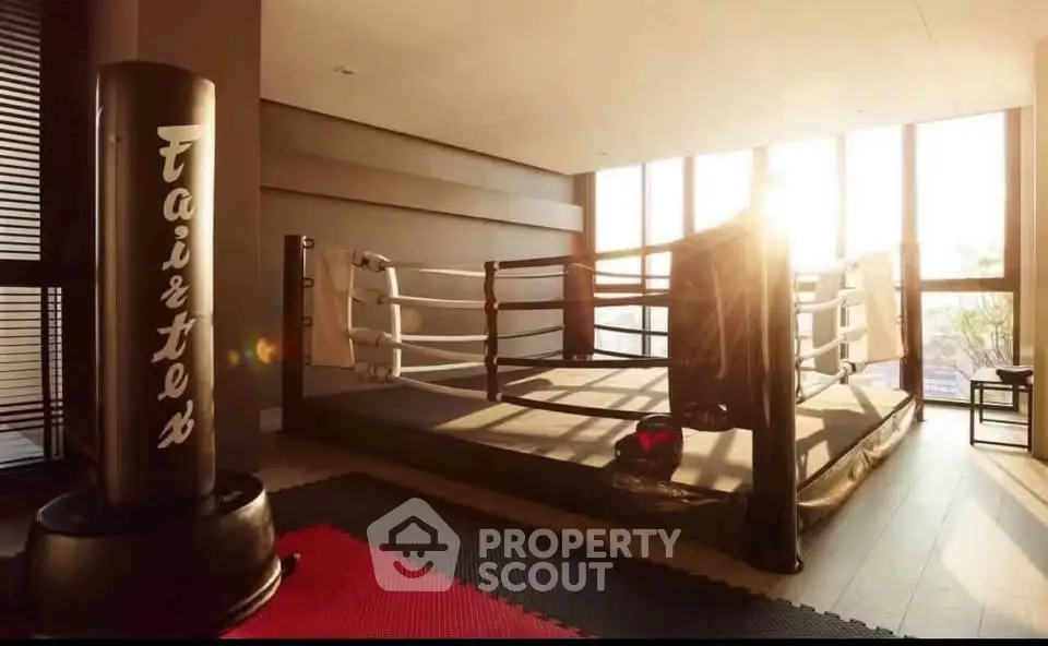 Spacious home gym with boxing ring and punching bag, perfect for fitness enthusiasts.