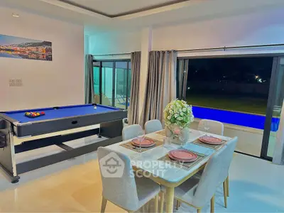 Luxurious open-plan living area with pool table and pool view