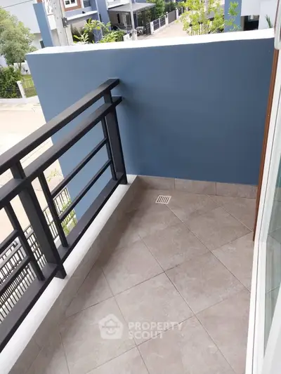 Charming small balcony with modern railing and tiled floor, perfect for cozy outdoor relaxation.