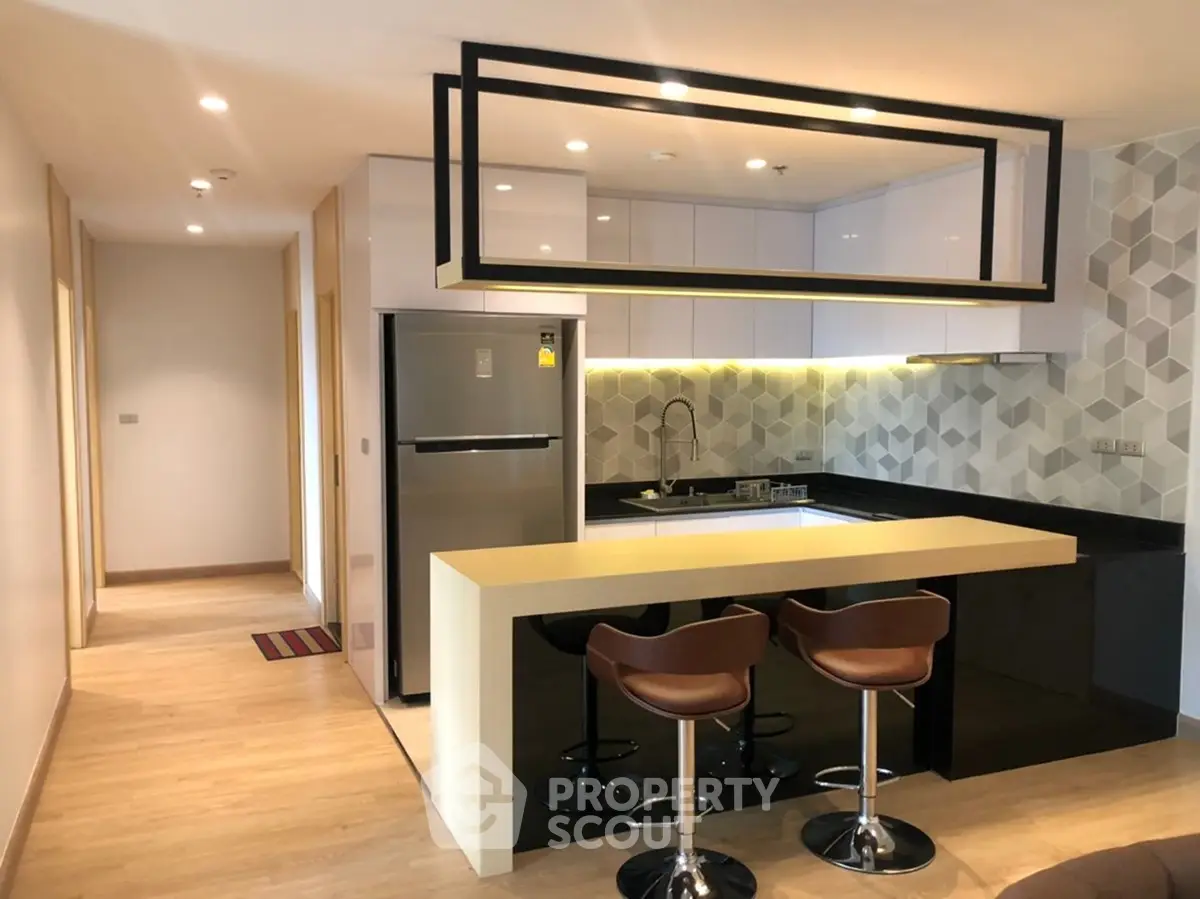 Modern kitchen with sleek design, featuring an open layout and stylish bar seating.