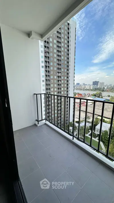 Spacious balcony with stunning cityscape view in modern high-rise apartment.