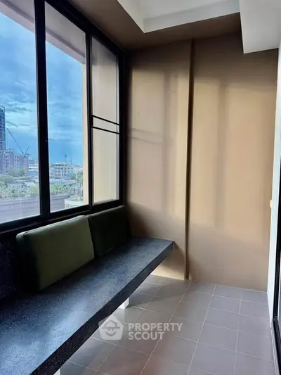 Modern balcony with city view and sleek seating area in urban apartment