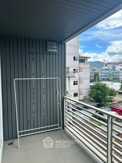 Spacious balcony with modern railing and city view, perfect for relaxation and outdoor activities.