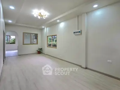 Spacious modern living room with elegant lighting and large windows for natural light.