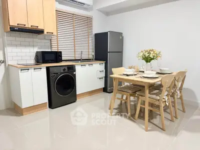 Modern kitchen with dining area, featuring sleek appliances and stylish decor for a cozy home atmosphere.