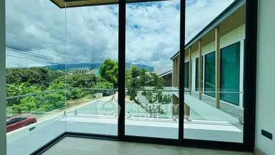 Stunning modern balcony with glass railing offering panoramic mountain views.