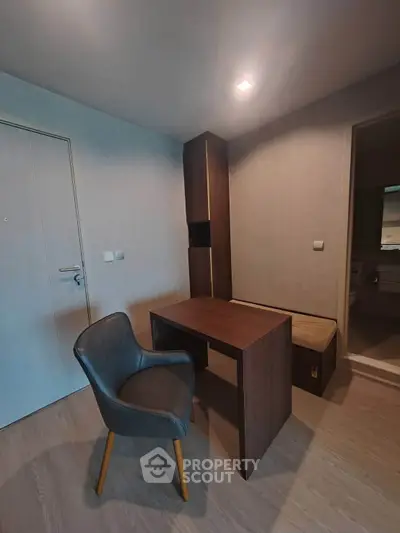 Modern study room with sleek wooden desk and comfortable chair in minimalist apartment.