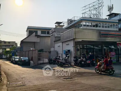 Convenience store with parking area in urban setting under bright sun