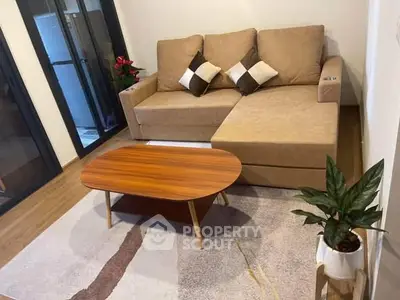 Cozy living room with beige sofa and wooden coffee table, perfect for relaxation.