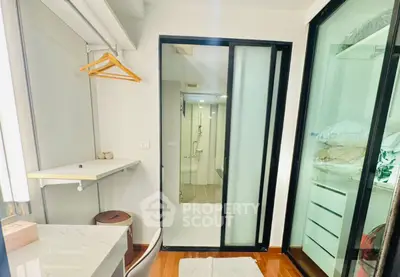 Modern compact bedroom with built-in closet and ensuite bathroom, featuring sleek sliding glass doors.