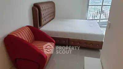 Modern bedroom with stylish bed and vibrant armchair, featuring a stunning balcony view.