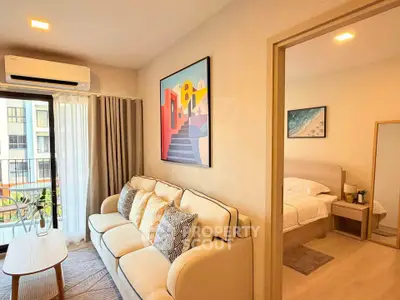 Modern living room with cozy sofa and stylish decor adjacent to a serene bedroom, perfect for urban living.