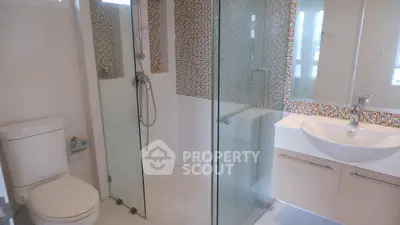 Modern bathroom with glass shower and mosaic tile accents