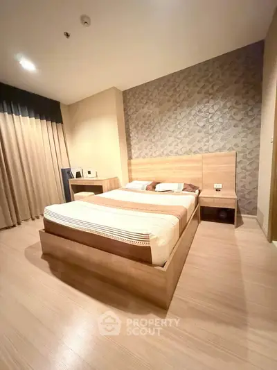 Modern bedroom with stylish wood flooring and elegant wallpaper accent wall.