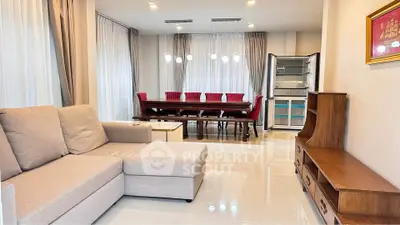 Spacious living room with elegant dining area and modern furniture, perfect for family gatherings.