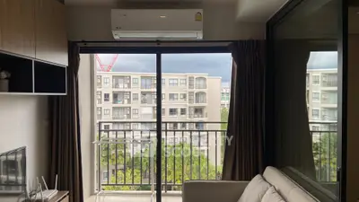 Modern apartment living room with balcony view of urban landscape