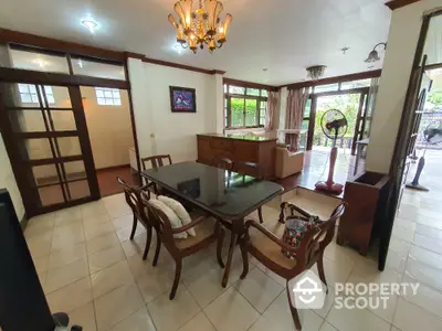 Spacious dining area with elegant chandelier and large windows for natural light