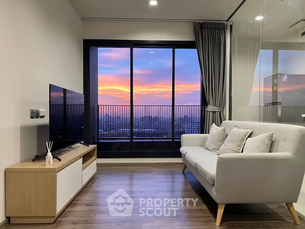 Modern living room with stunning sunset view through large glass doors, featuring sleek furniture and elegant decor.