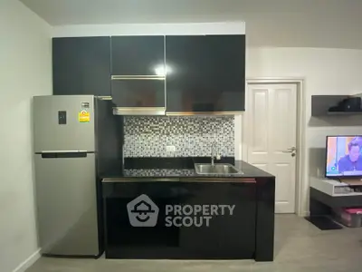 Modern kitchen with sleek black cabinets and stainless steel fridge