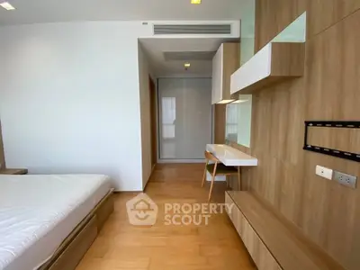 Modern bedroom with wooden flooring and built-in storage solutions