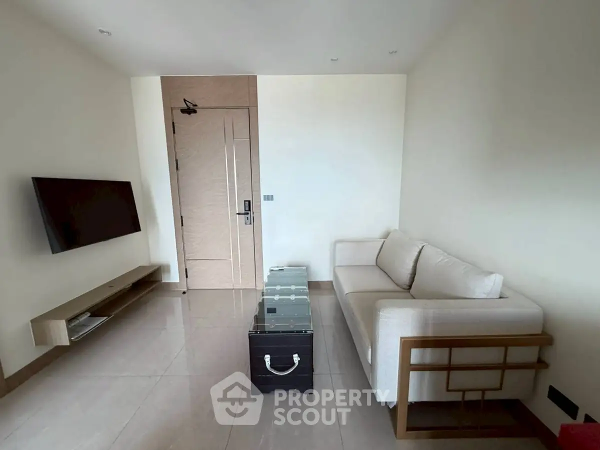 Modern living room with sleek TV setup and stylish sofa in a minimalist design.