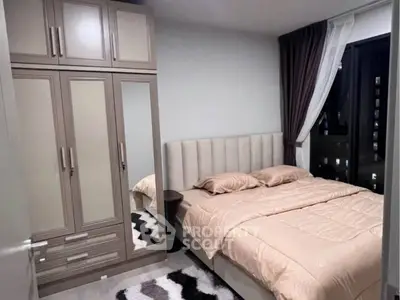 Cozy bedroom with elegant wardrobe and plush bedding in modern apartment.