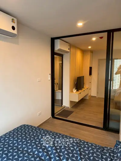 Modern bedroom with sliding glass doors and air conditioning in a stylish apartment.