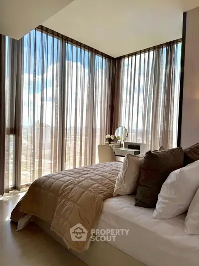 Luxurious bedroom with floor-to-ceiling windows offering stunning city views and elegant decor.