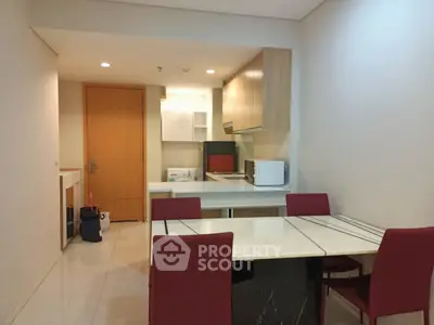 Modern kitchen with dining area featuring sleek cabinetry and contemporary furniture.