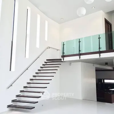 Modern minimalist interior with floating staircase and glass balcony in luxury home