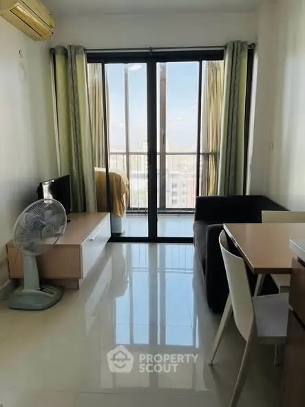 Modern living room with balcony view, sleek furniture, and natural light.