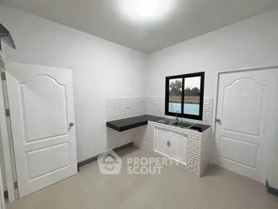 Modern minimalist kitchen with sleek black countertop and white brick backsplash