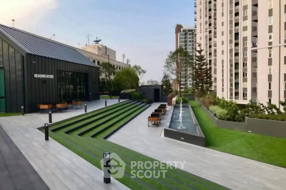 Luxurious rooftop garden with modern seating and water feature in urban high-rise complex.