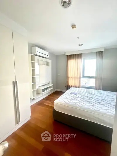 Bright and airy bedroom with hardwood floors and modern furnishings in a stylish apartment.