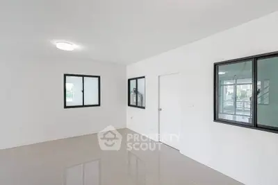 Spacious modern living room with large windows and sleek tile flooring